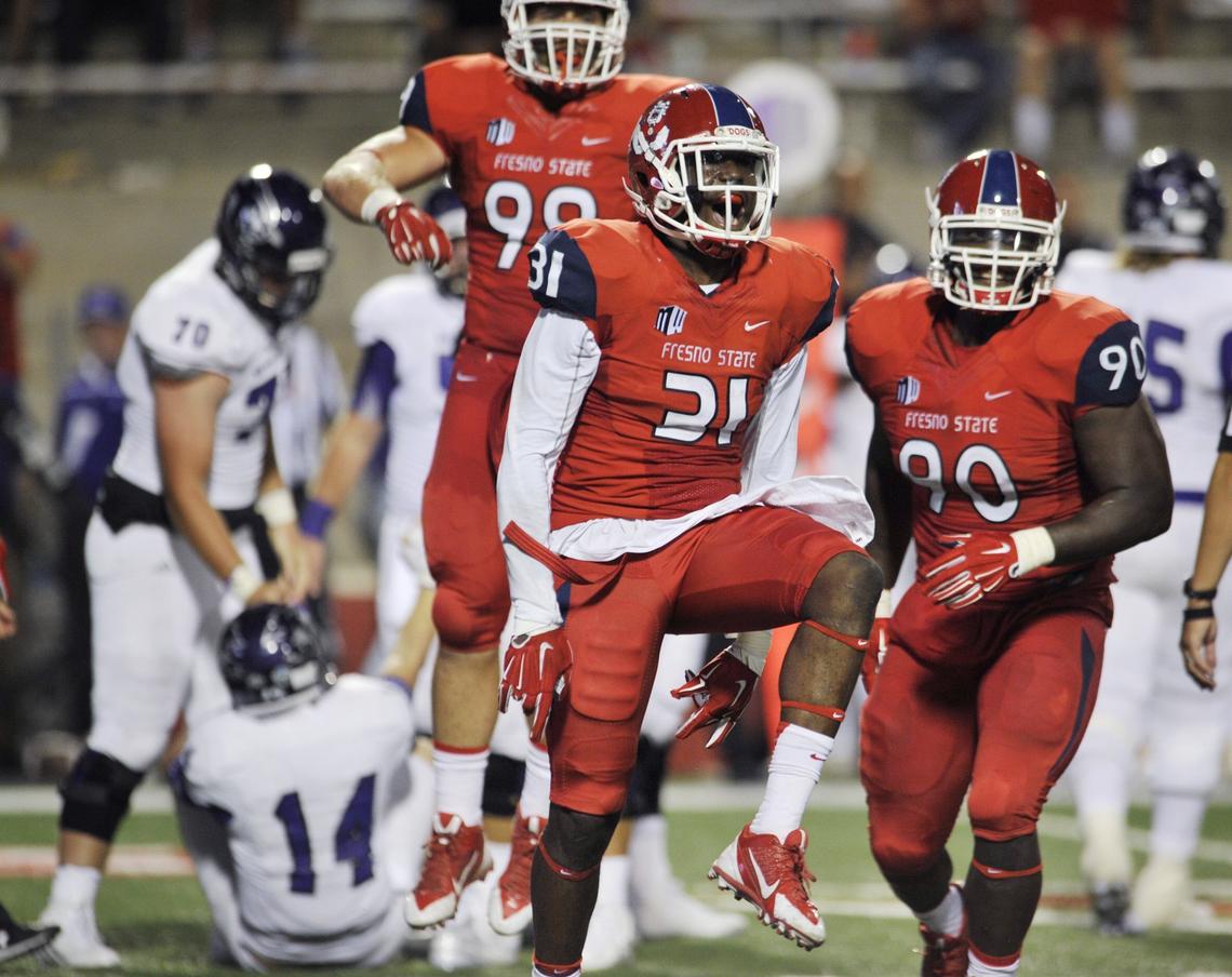 Fresno State Ejiro Ederaine, center, celebrates after sacking Abilene Christian quarterback Parker McKenzie, on the ground, in second half action Thursday, September 3, 2015 in Fresno, Calif.