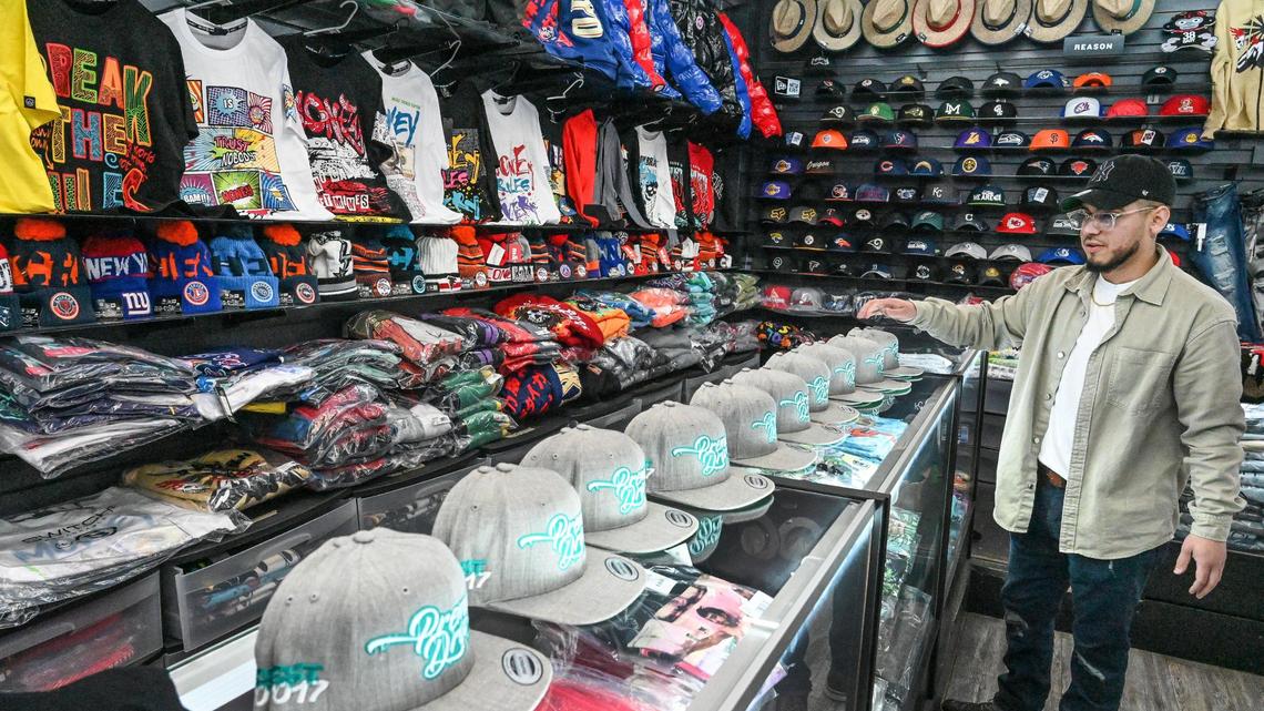 Anthony Arreguin of All Pro Customs embroidery displays some recent custom hat embroidery work inside the Cali Smoke Shop on Ventura Avenue east of downtown Fresno on Tuesday, Feb. 28, 2023.