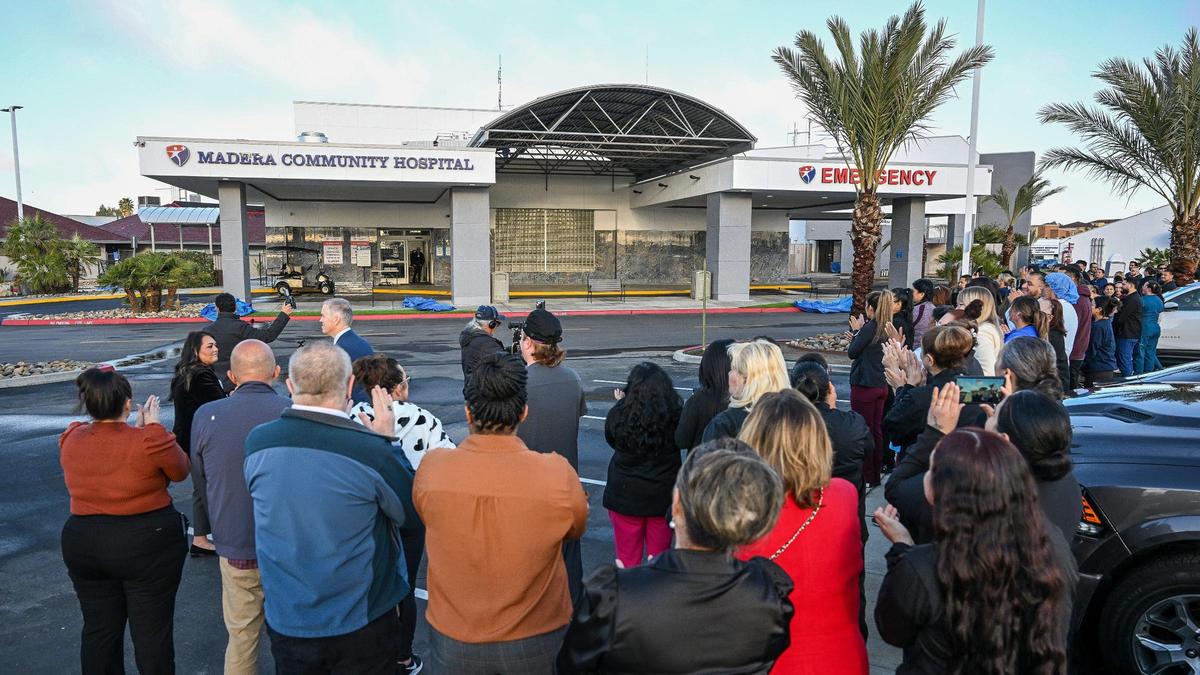 Hospital staff, administrators, and local legislators gather to witness the unveiling of the signs for Madera Community Hospital in Madera during its reopening on Tuesday, March 18. 2025.