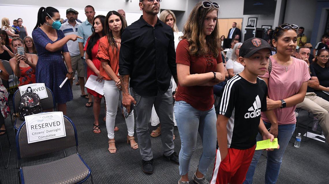 Around 40 people line up to voice an opinion against mask-wearing including Austin Perez, 10, right, with his mother Vanessa Perez, far right, at the Clovis Unified School Board meeting Wednesday night, July 21, 2021 in Clovis.
