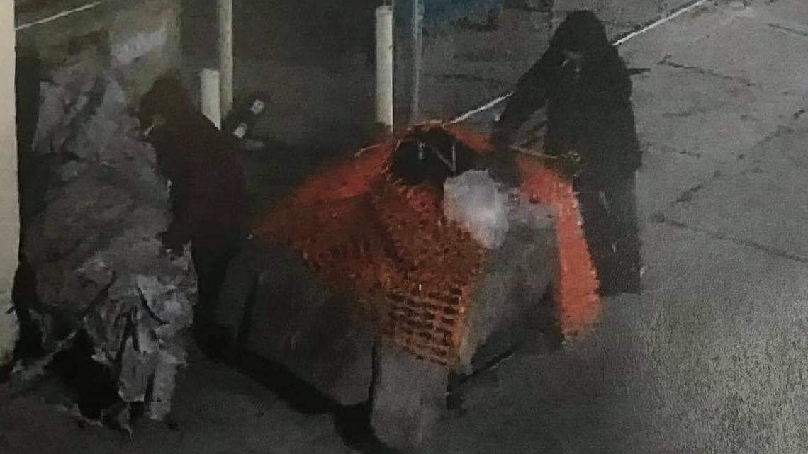 A photo taken from a surveillance camera shows two people stealing a smoker from Just The Tip restaurant in downtown Fresno. The smoker is on the left.