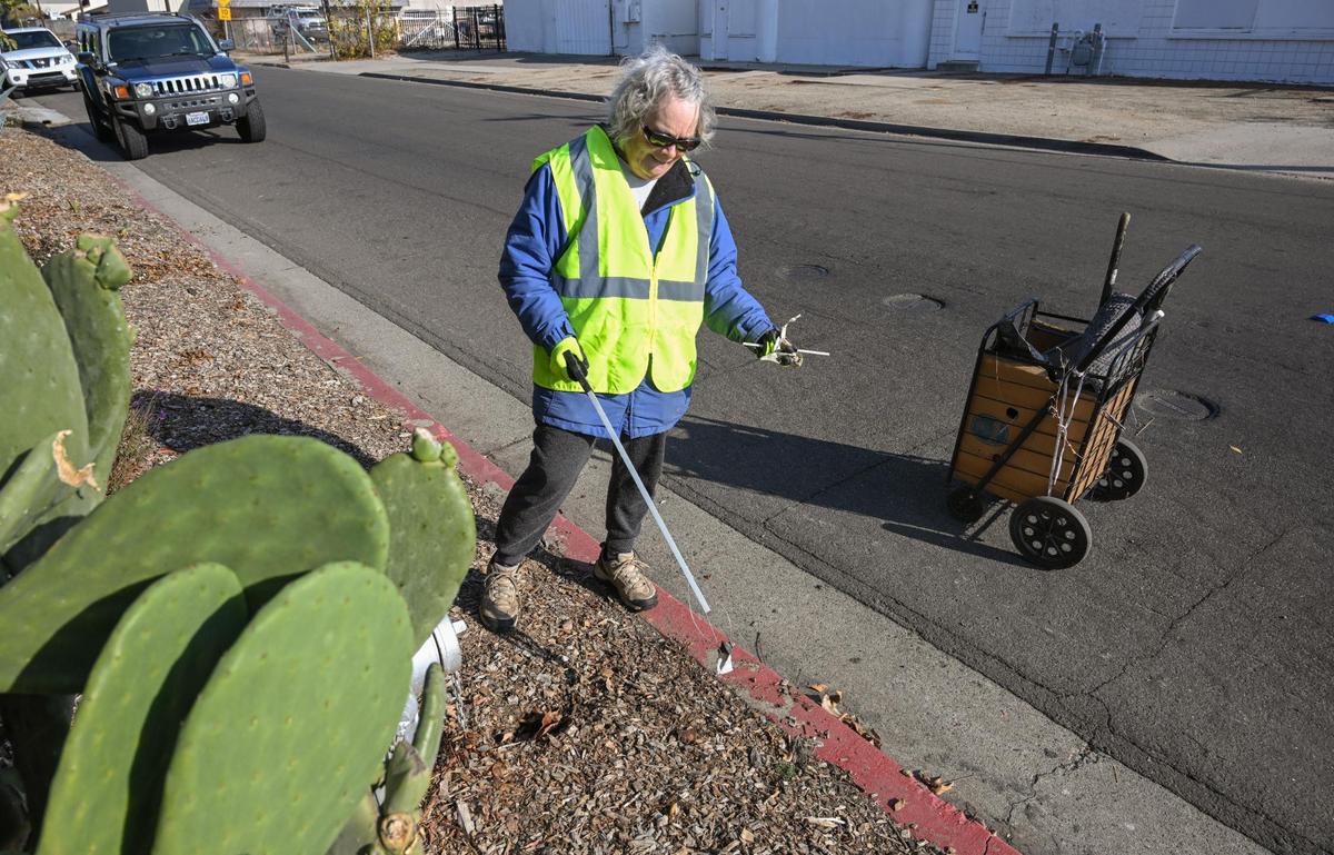 Volunteer Julie Guyette of Fresno picks up trash along Harrison Avenue in north Fresno during a Beautify Fresno “neighborhood blitz” cleanup event on Saturday, Dec. 9, 2023. “You feel like you’ve done something good,” says Guyette, who volunteers regularly.