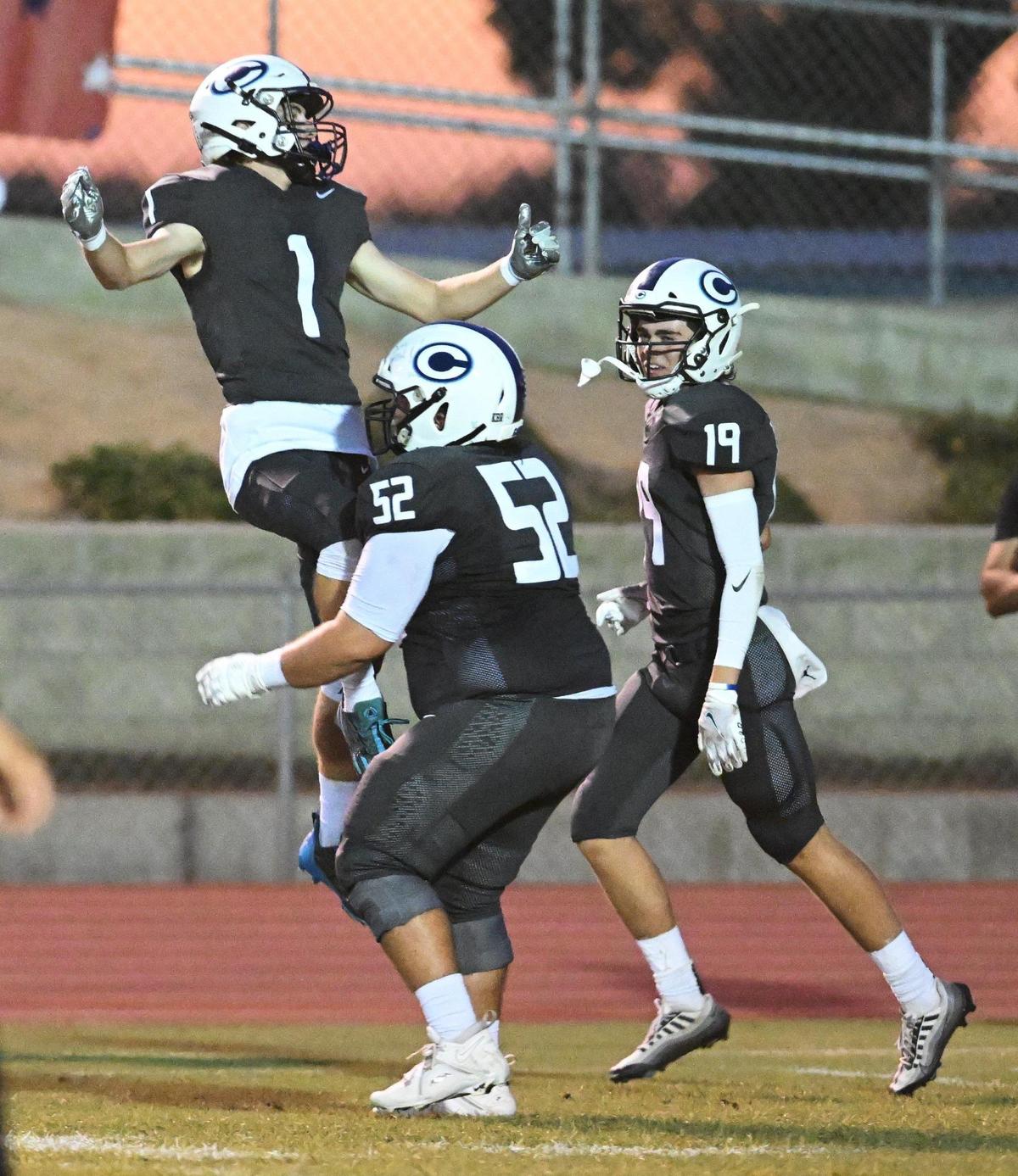 Central Valley Christian’s Bryce Cook, left, celebrates an early touchdown against Clovis North with teammates Tyler Hughes, center, and Caden Ritchie during their game at CVC on Friday, Sept. 8, 2023.