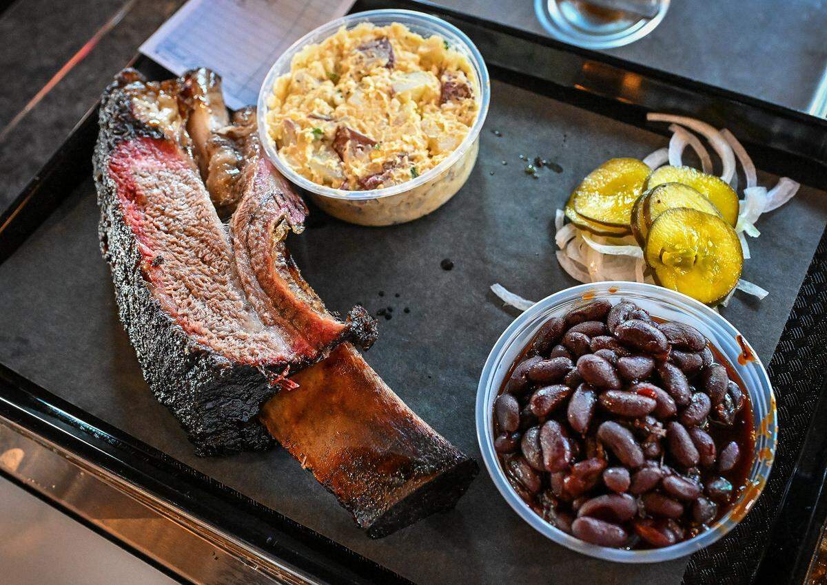 A large beef rib with sides of potato salad and pit beans await a customer at Horn Barbecue in Fresno's Granite Park shopping center on Friday, Jan. 23, 2026.