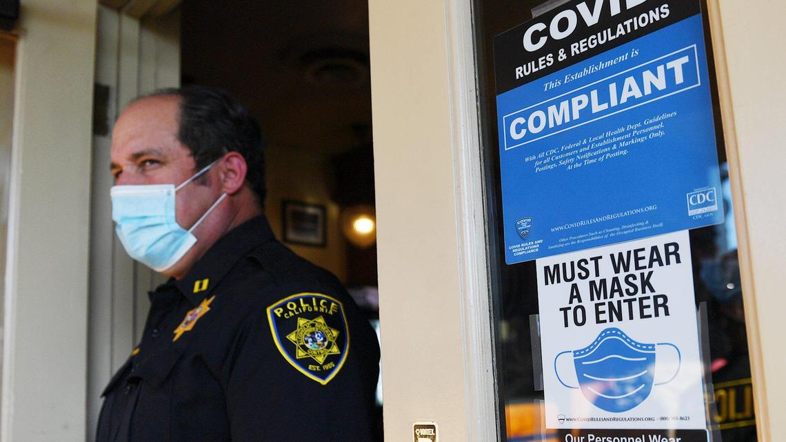 California Department of Alcoholic Beverage Control (ABC) task force supervising agent Jason T. Montgomery exits Yosemite Falls Cafe in Fresno in August. Agents have been cracking down on violations of COVID-19 restrictions.