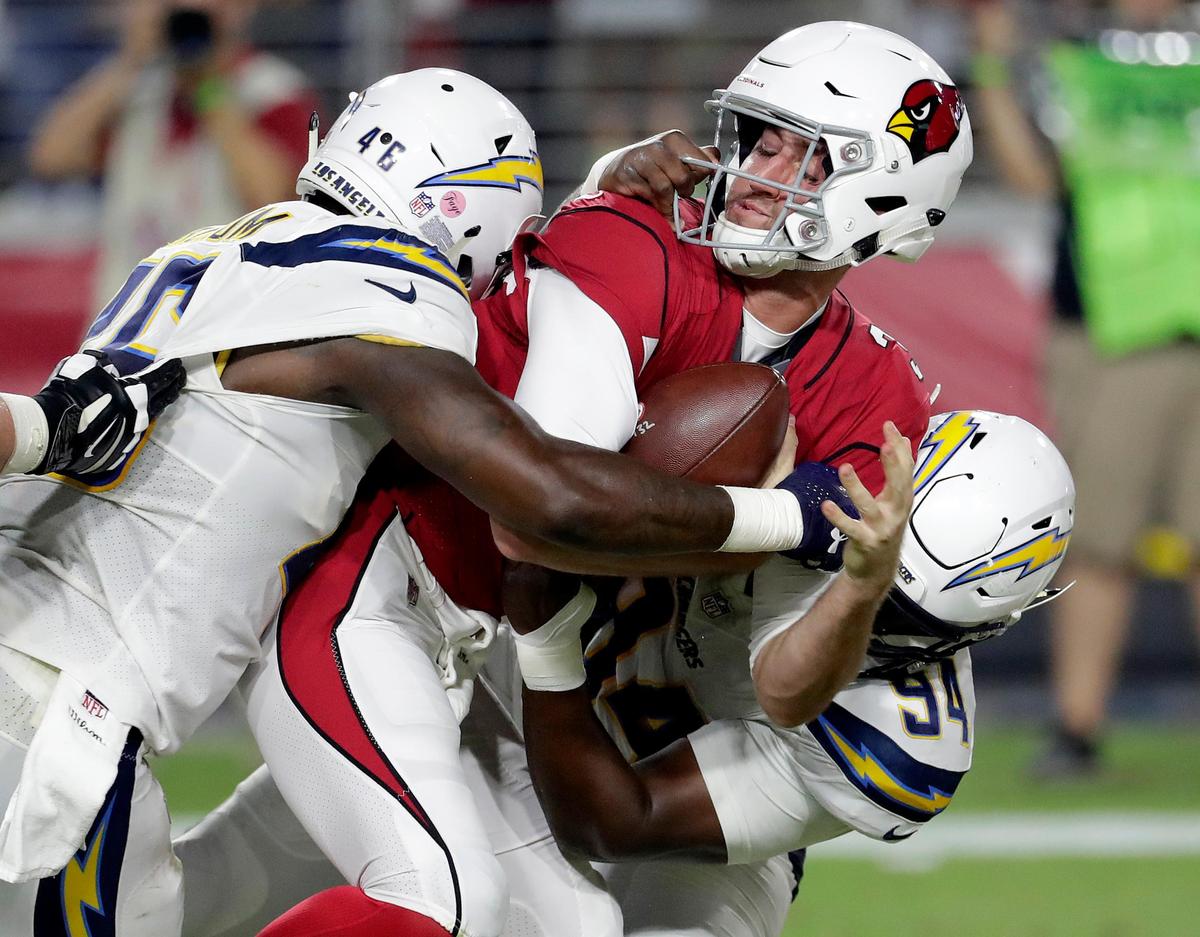 Arizona Cardinals quarterback Josh Rosen (3) has his face mask grabbed by Los Angeles Chargers defensive tackle Corey Liuget (94) for a 15-yard penalty during the first half of a preseason NFL football game, Saturday, Aug. 11, 2018, in Glendale, Ariz.