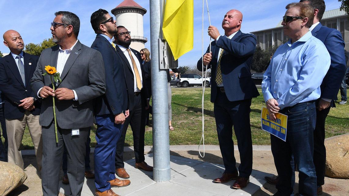 Mayor Jerry Dyer raises the flag of Ukraine at Eaton Plaza in March. Next to him are City Council members Garry Bredefeld and Tyler Maxwell. Councilmember Miguel Arias holds the sunflower next to Luis Chavez and Nelson Esparza.