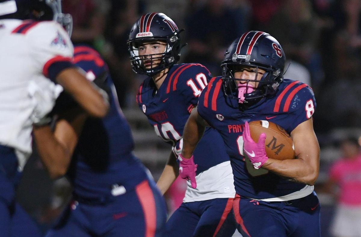 San Joaquin Memorial’s Brandon Ramirez, right, takes the handoff from Memorial quarterback Carson Dean, left, in first quarter action against Garza High Friday, Oct. 21, 2022 in Fresno.