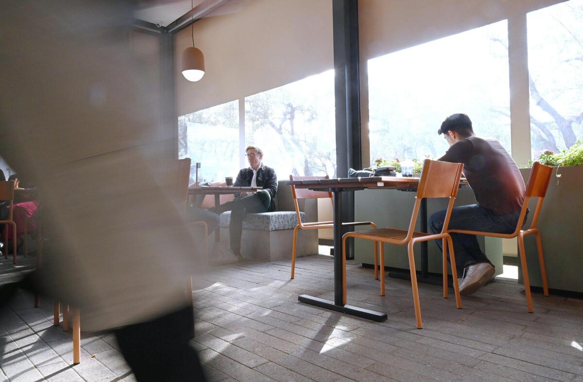 Customers relax in the enclosed patio of Otherside Cafe, Brandon Smittcamp and partners’ latest venture offering espresso drinks, food and desserts in northeast Fresno.