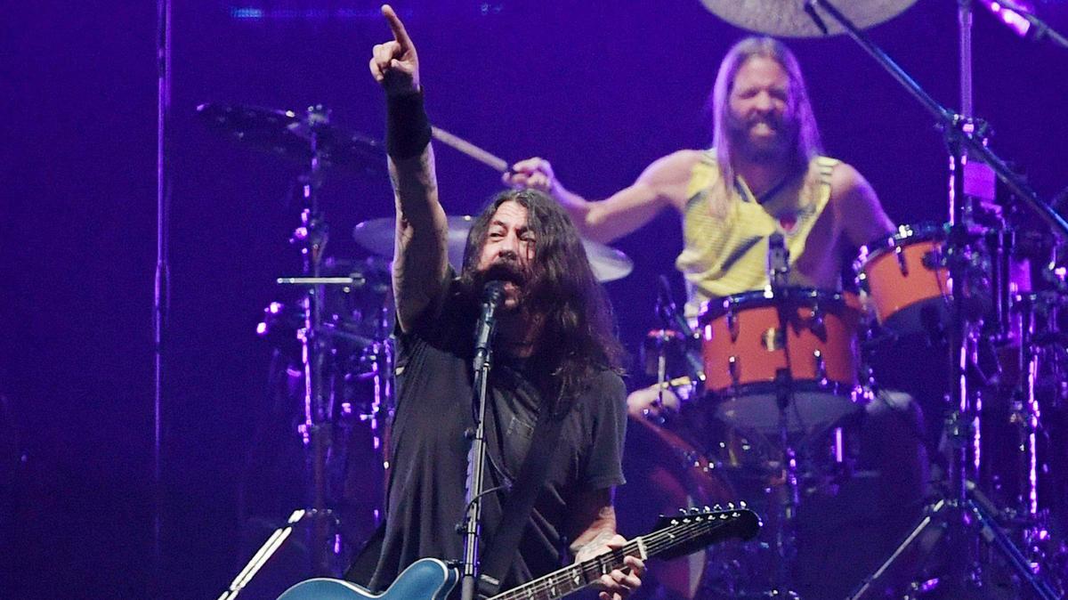 Foo Fighters lead singer Dave Grohl, left, with drummer Taylor Hawkins in the background at Save Mart Center Thursday, Dec. 9, 2021 in Fresno.