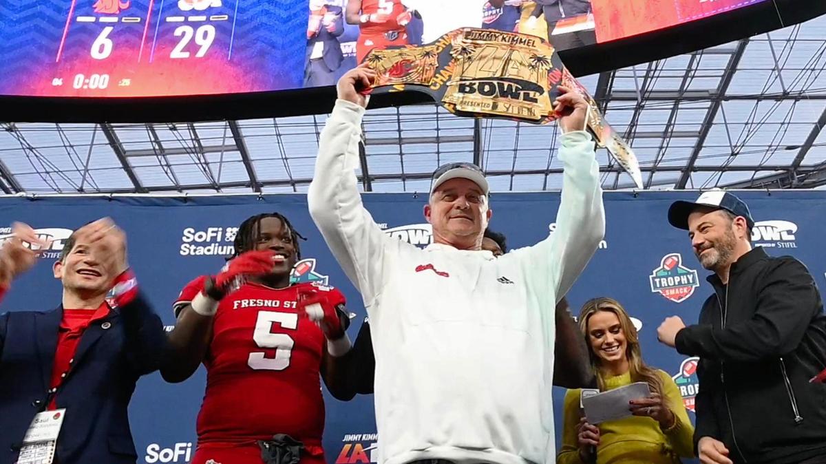Fresno State head coach Jeff Tedford, center, lifts the championship belt after Fresno State defeated Washington State 29-6 at the Jimmy Kimmel LA Bowl Saturday, Dec. 17, 2022 in Inglewood, CA. Joining the celebration, from left, Fresno State President Saúl Jiménez-Sandoval, game MVPs defensive lineman Devo Bridges and (behind Tedford) running back Jordan Mims, ABC on-field reporter Molly McGrath and Kimmel.