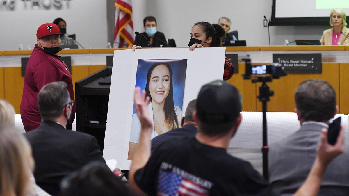An angry Rosalinda Mendez, right, holds up a photo of her daughter Emi Fair, 16, in an example of her outfit which was was rejected for the yearbook due to the dress code, while her son Cesar Fair is seen to the left at the Clovis School Board meeting Wednesday night, Nov. 10, 2021 in Clovis.