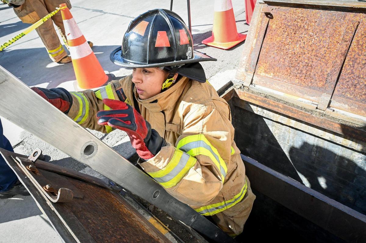 Carmen Iniguez of Fresno climbs out of a cellar after crawling through ventilation tubes in a search-and-rescue drill during the Fresno Fire Department’s annual “Firefighter for a Day” event where citizens can get an inside look at the job of a firefighter, at the department’s training grounds in Fresno on Saturday, Oct. 22, 2022.