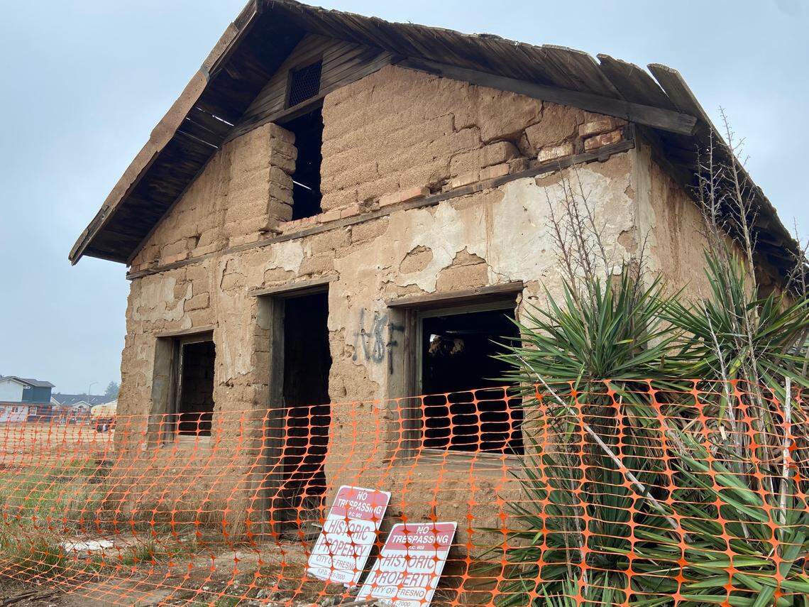 The Jose Garcia (Brewer) Adobe sits behind a plastic fence near Shaw Avenue west of Highway 99 in Fresno, California, on December 5, 2021. The adobe brick and hardpan structure, placed on the Local Register of Historic Resources in 1997, is under threat by a developer who originally requested its demolition.