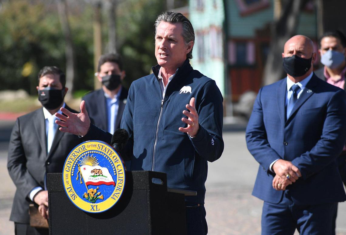 Gov. Gavin Newsom, flanked by local officials including state Assemblyman Joaquin Arambula, D-Fresno, left and Fresno Mayor Jerry Dyer, right, addresses the issue of COVID-19 vaccines in the San Joaquin Valley, Wednesday, Feb. 10, 2021, at the Fresno Fairgrounds.