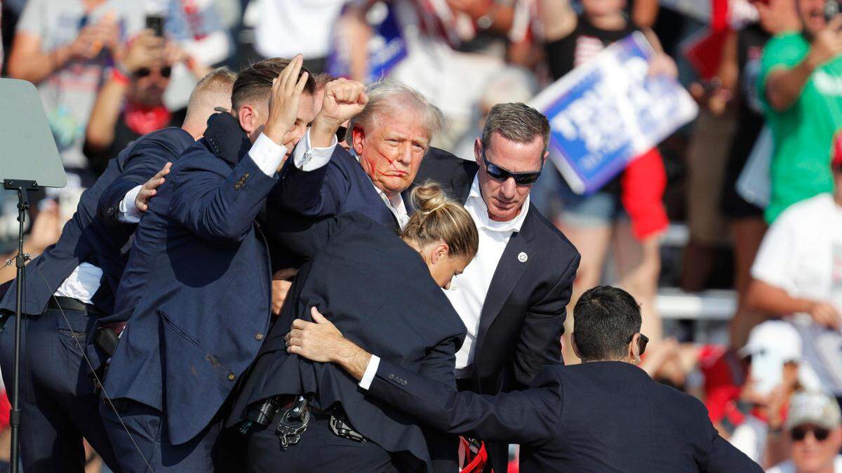 El ex presidente Donald Trump levanta el puño mientras el servicio secreto lo saca del escenario después de un incidente durante un mitin de campaña en Butler Farm Show Inc. en Butler, Pensilvania, el 13 de julio.