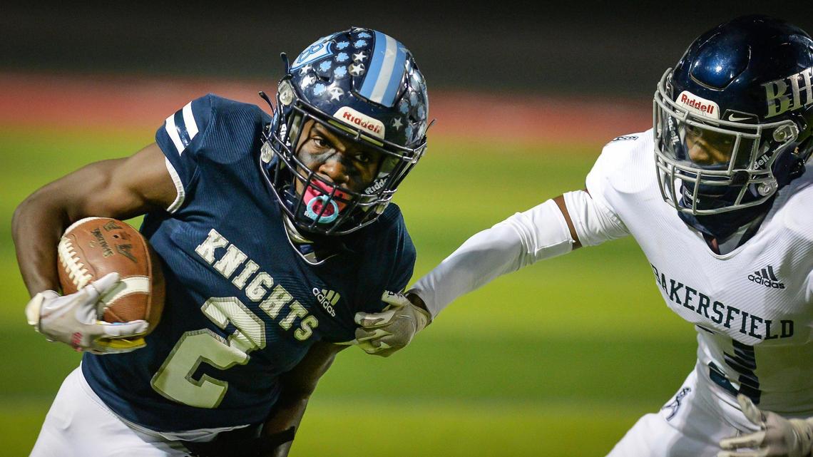 Bullard’s Jalyn Utendahl, left, takes the ball to the outside as Bakersfield’s Mark Slocumb chases during their Central Section Division II football championship game held at McLane Stadium on Friday, Nov. 26, 2021.