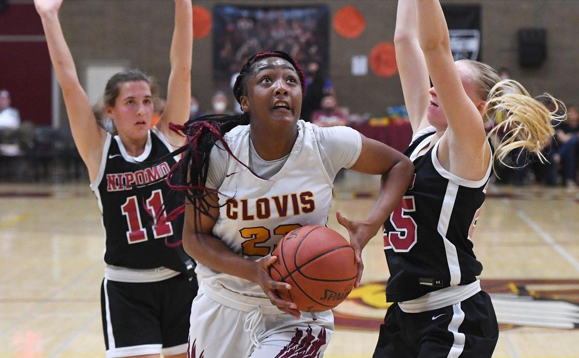 Clovis West’s Etoyah Montgomery, ceter, drives through Nipomo’s Kayden Sanders, left, and Allyson Cramer, right, in Open Division action Saturday, Feb. 19, 2022 in Fresno. Clovis West toppled Nipomo 68-18.