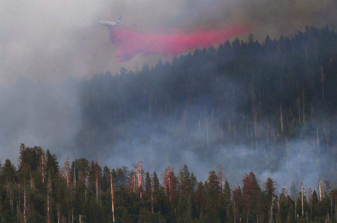 Fire retardant is dropped on the Washburn Fire as it burns in late afternoon light near the south entrance of Yosemite National Park Saturday, July 9, 2022 near Fish Camp.