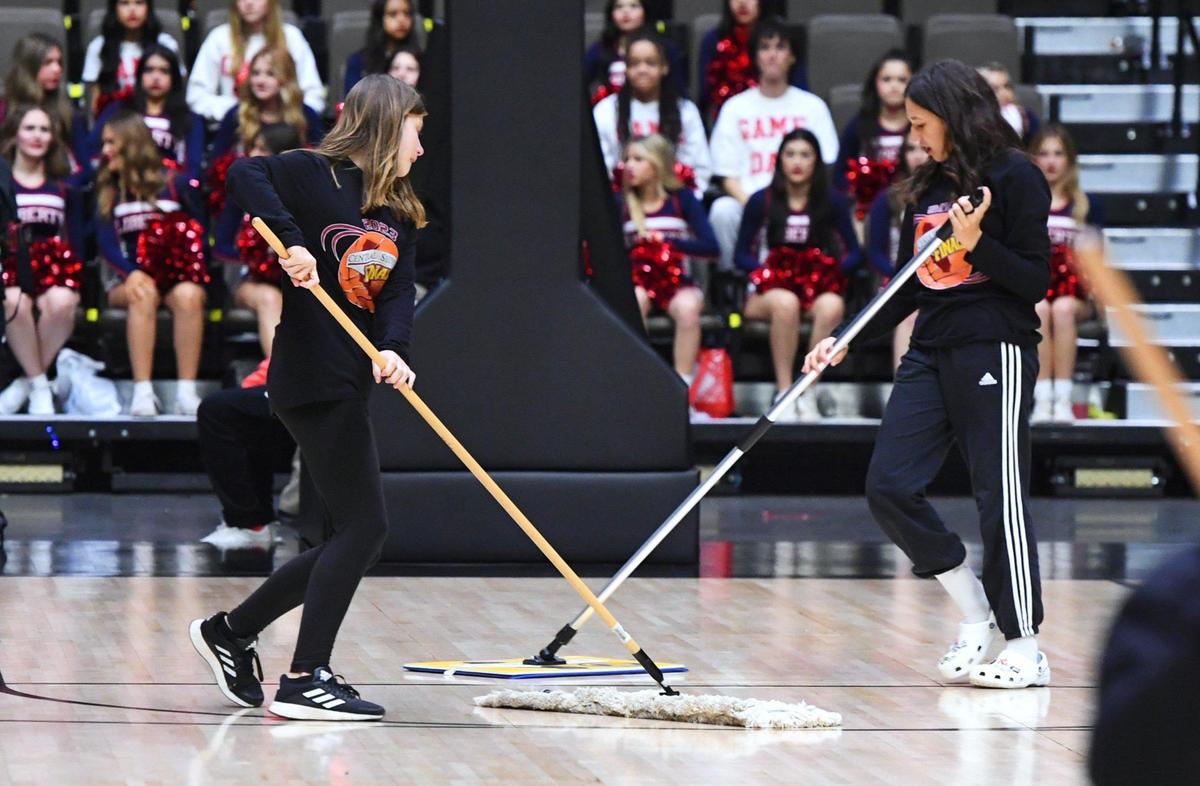 On-court personnel mop an area beneath the net where rain has been leaking from Selland Arena’s roof to the court at the CIF Central Section basketball championships Friday, Feb. 24, 2023 in Fresno.
