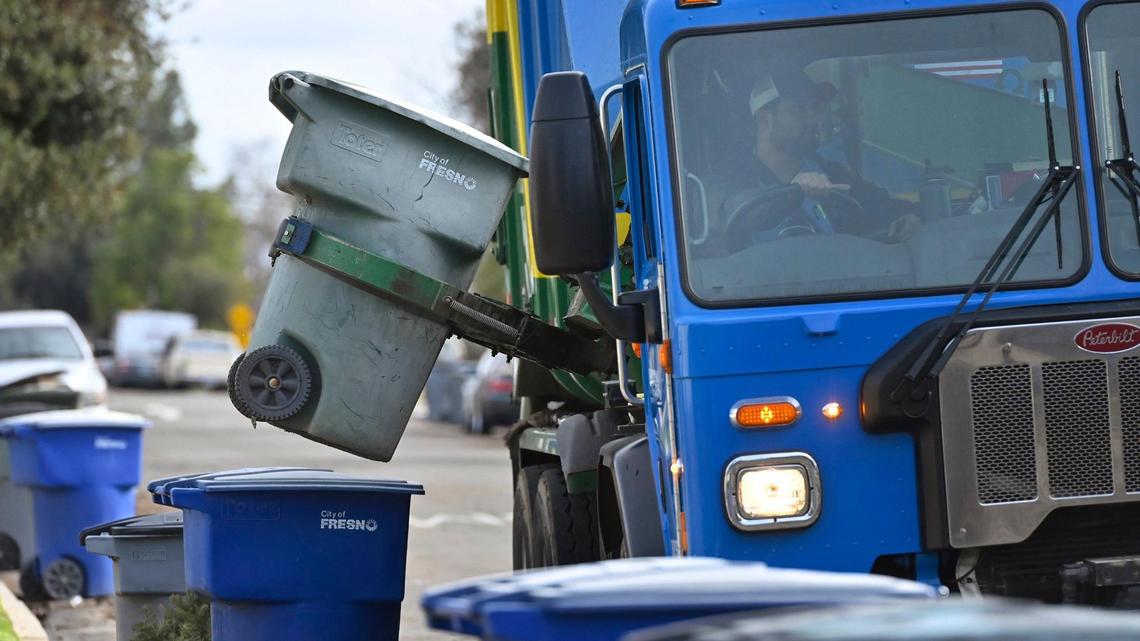 A green recycling can is emptied as City of Fresno solid waste trucks drive their collection routes in central Fresno Wednesday, Jan. 3, 2024.
