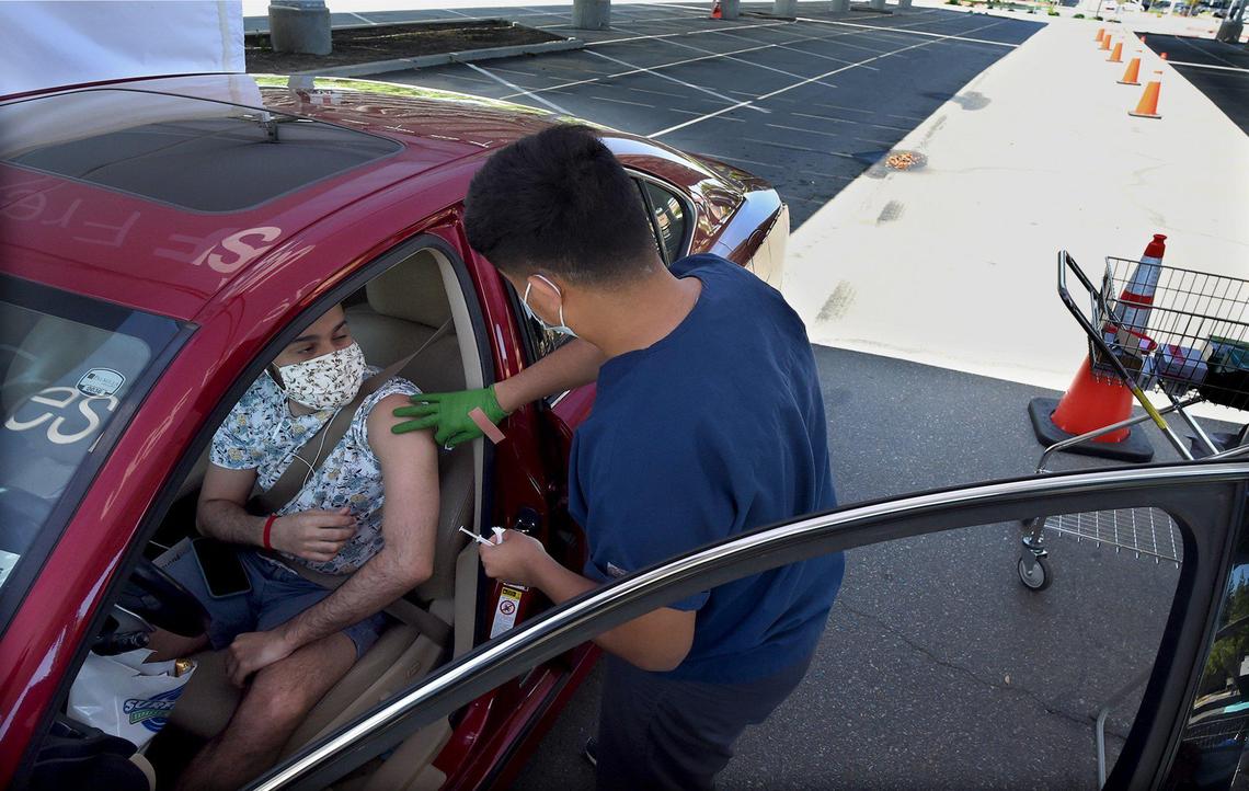 In a nearly vacant Fresno City College parking lot being used for Covid drive-through clinic, UCSF Vaccination Assistant Specialist Darian Galvez readies a Pfizer vaccine for a client Friday May 7, 2021.
