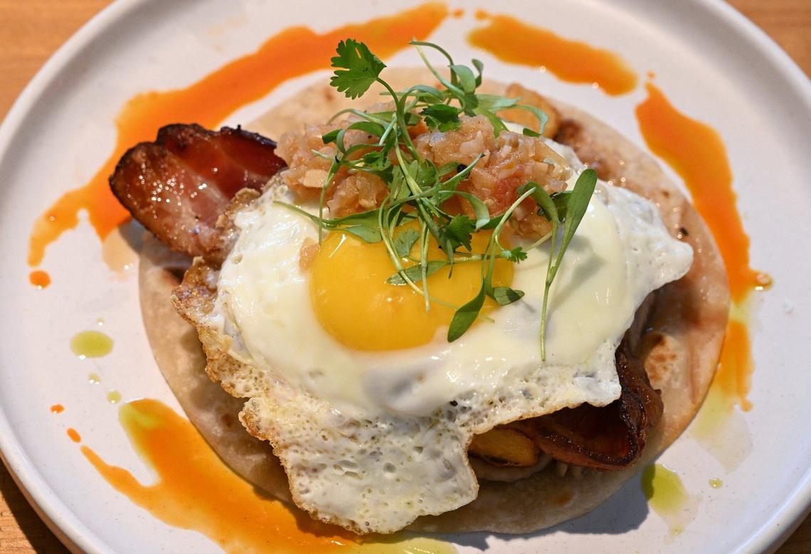 Yolked Kitchen’s Cen Cal Breakfast Taco includes sliced tri tip, Salsa Macho, an egg, rfried beans and potatoes and a slice of bacon on an open homemade flour tortilla. Photographed Thursday, July 11, 2024 in Clovis.