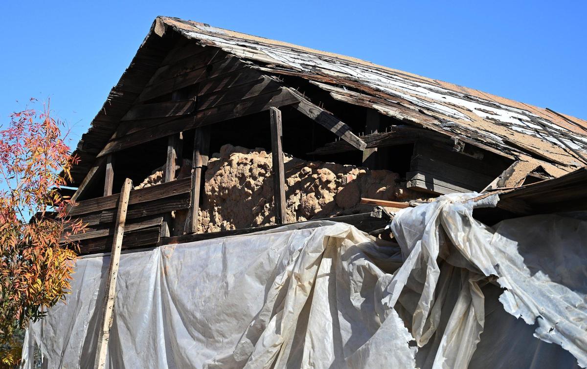 Original adobe bricks can be seen as the historic Jose Garcia Adobe sits wrapped in tattered plastic Tuesday, Nov. 28, 2023 in Fresno.
