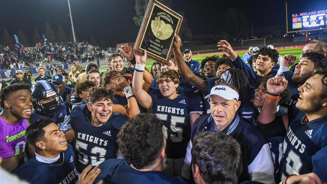 Bullard coach Don Arax, lower right, celebrates with the Knights after clinching the Central Section Division II football championship against Bakersfield at McLane Stadium on Friday, Nov. 26, 2021.