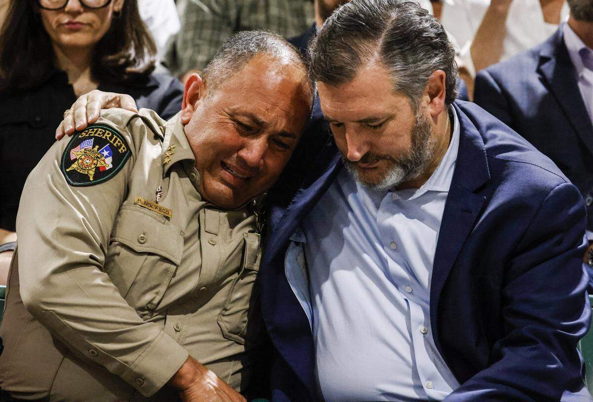 El sheriff del condado de Uvalde, Rubén Nolasco, llora mientras el senador estadounidense Ted Cruz de Texas lo consuela durante una reunión comunitaria en mayo de 2022 en el Fairplex del condado de Uvadle, luego de un tiroteo masivo en la escuela primaria Robb en Uvalde, Texas.