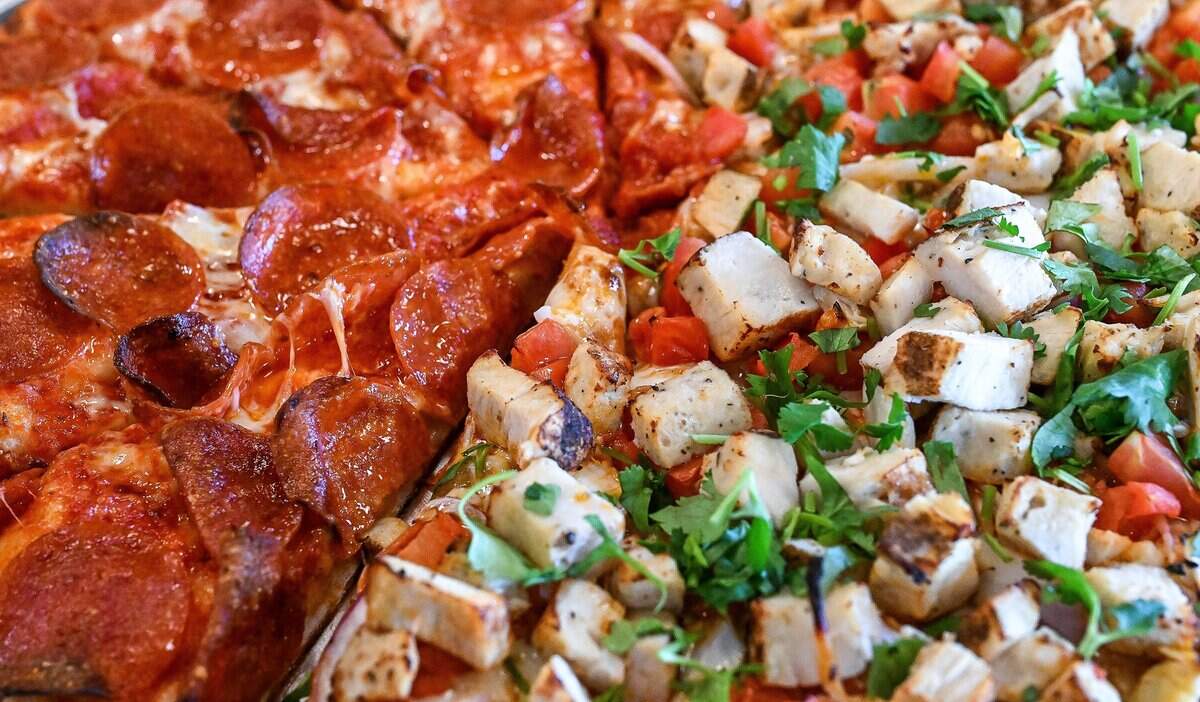 A pizza with half pepperoni and half butter chicken is prepared at The Curry Pizza Company's newest location on Fowler southeast of Belmont in the Sunnyside area of Fresno. This location is the first to have a full bar.