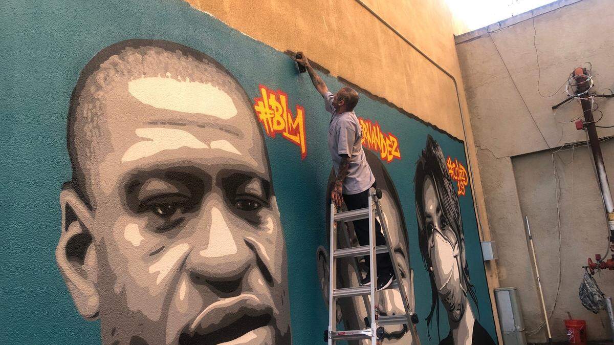 Fresno muralist Omar “Super” Huerta puts on finishing touches on his paintings of George Floyd, George Fernandez and nurses for COVID-19 on Tuesday, June 16, 2020.