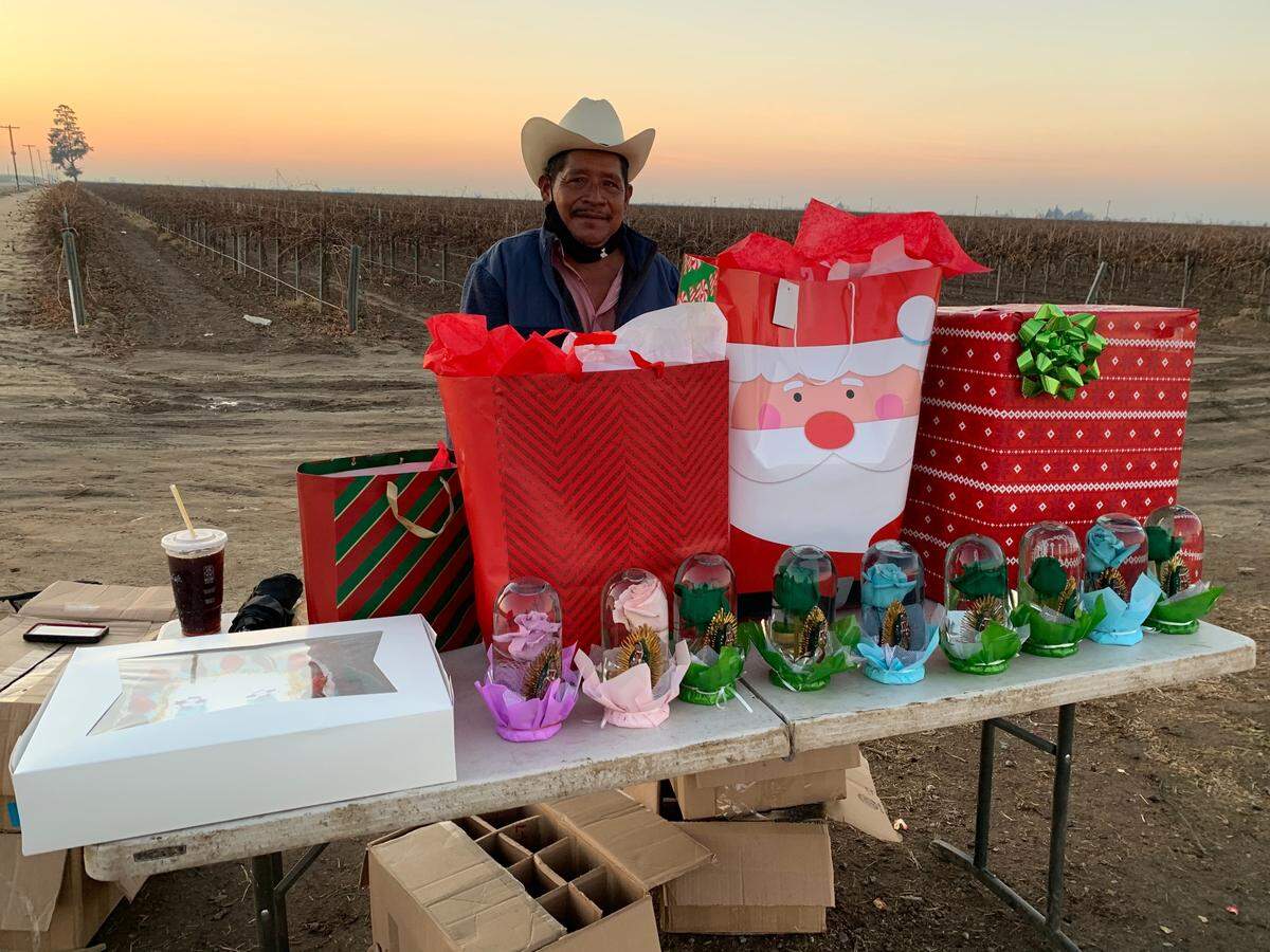 Guillermo Lozano at his flower stand outside Madera, California after receiving more Christmas gifts from sisters Fabiola and Jessica Ochoa.
