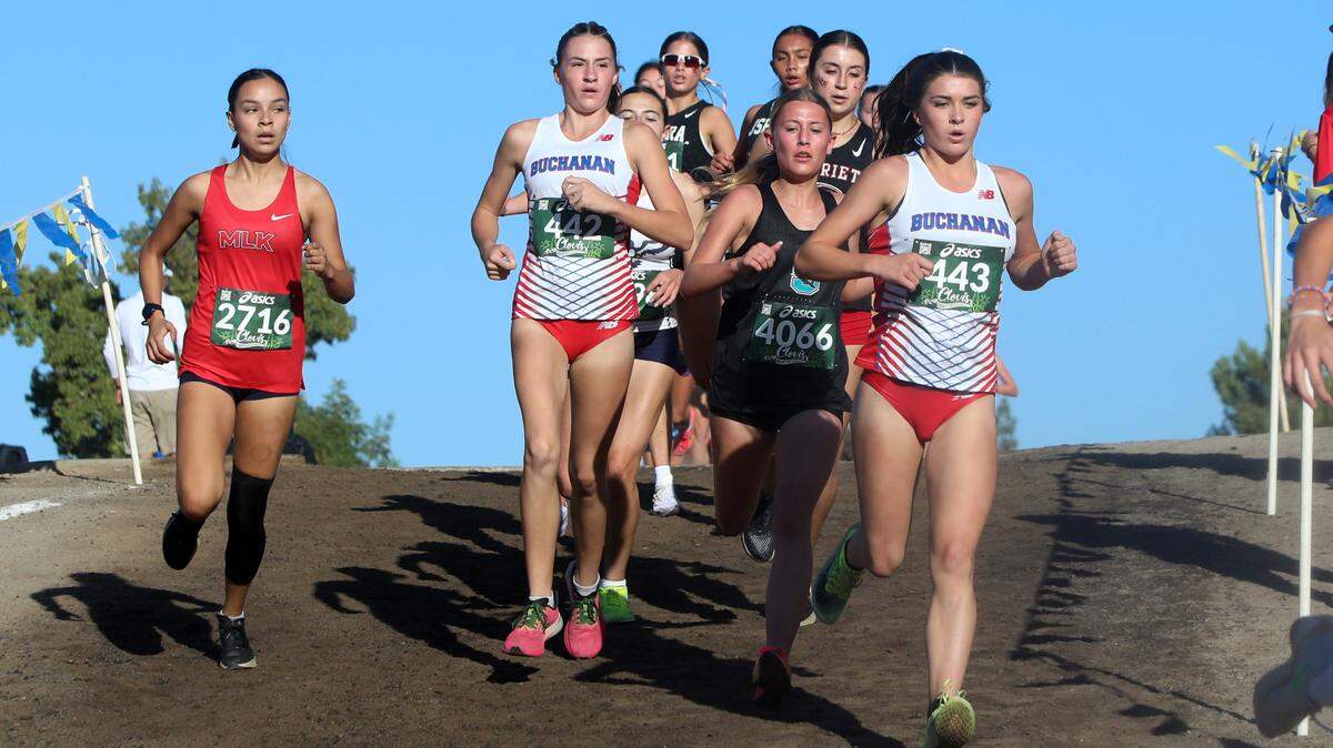Buchanan High freshman Brooklyn Buckley (20th, 17:52.3) and junior Kynzlee Buckley (15th, 17:50.5) run with a pack approaching the mile mark in the Bill Buettner race of the 2024 Asics Clovis Cross Country Invitational at Woodward Park on Oct. 12, 2024. Buchanan won the team title with 65 points, ahead of runnerup JSerra Catholic.