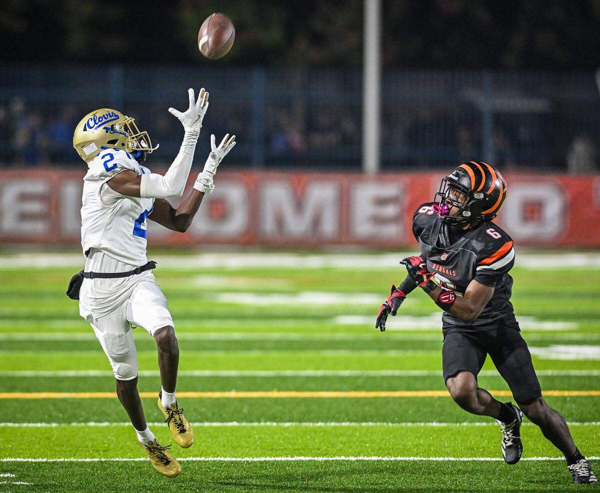 Clovis' Carlos Young, left, catches a deep pass while defended by Central East's Jontae Della during their Central Section Division I-AA championship game at Deran Koligian Stadium on Friday, Nov. 21, 2025.