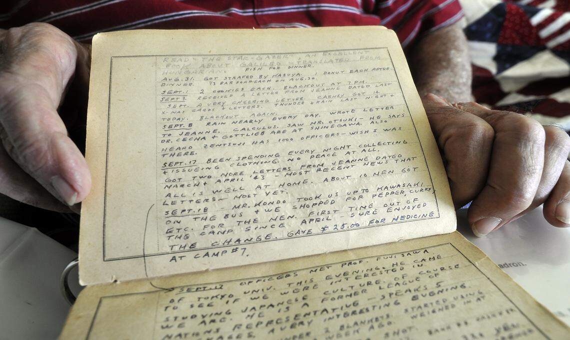 U.S. Navy veteran Jack Schwartz holds his diary, written in tiny lettering to save paper, when he was a prisoner of war during World War II.