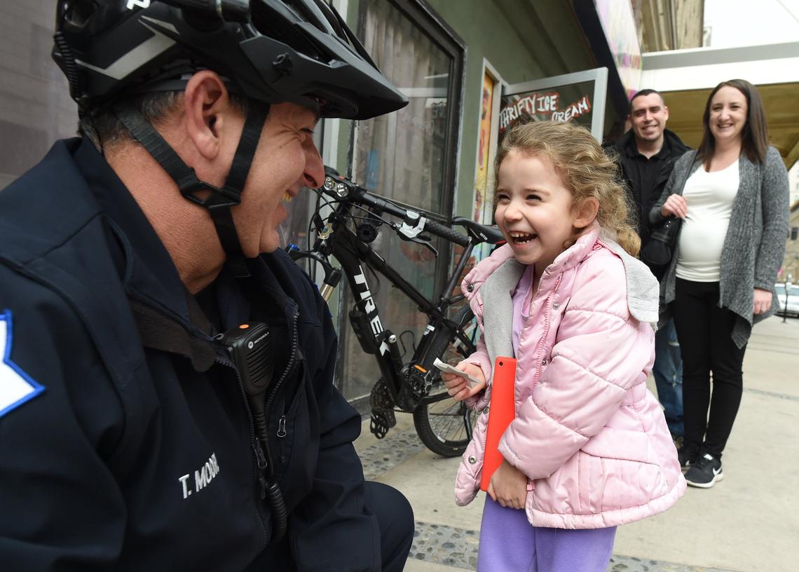 T.J. Moore, bike patrol member of the Downtown Police Unit, (nickname on the street: â€œGummy Bearâ€) gets a giggle out of 4-year-old Elara Arroyo, after giving her a badge sticker, as she and parents Edward and April Arroyo visit Fulton Street in downtown, Feb. 28, 2019.