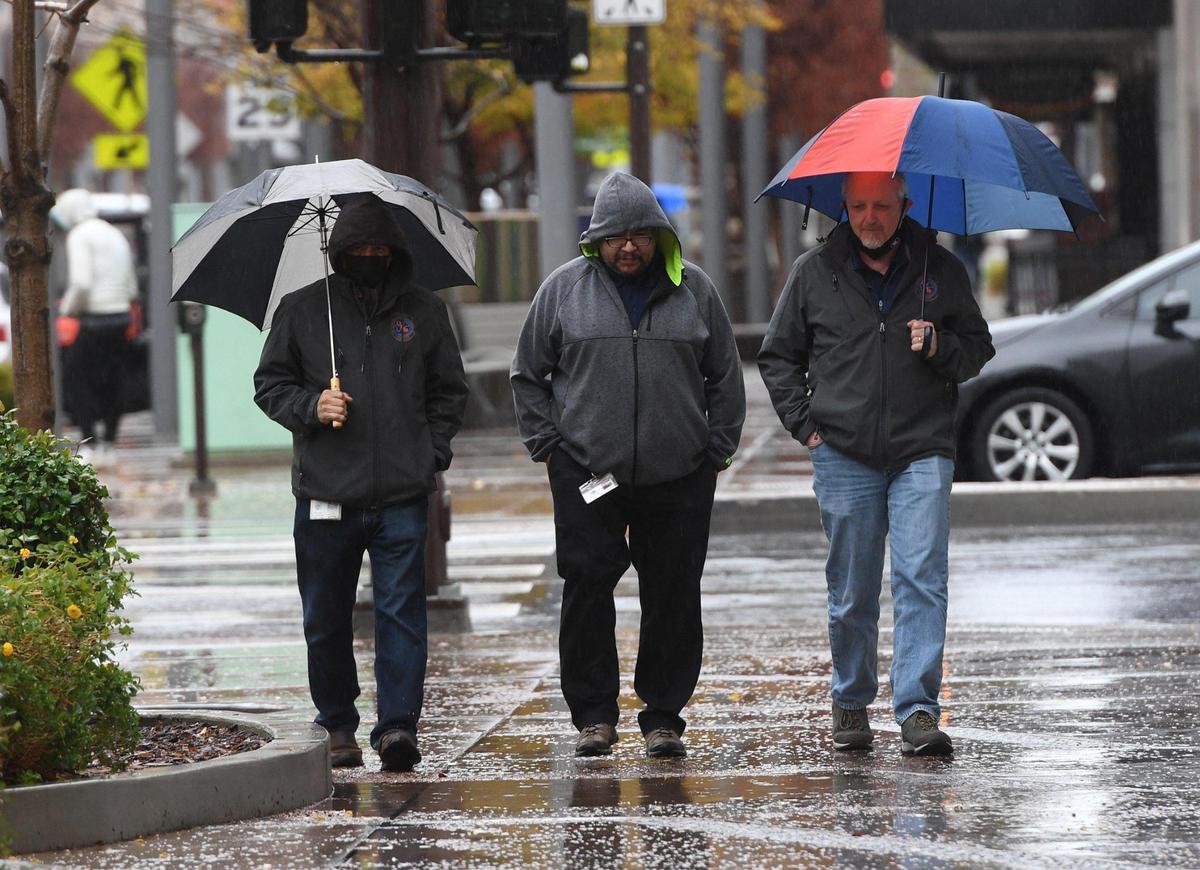 Pedestrians on Fulton Street walk through the drizzle of the storm Tuesday, Dec. 14, 2021.