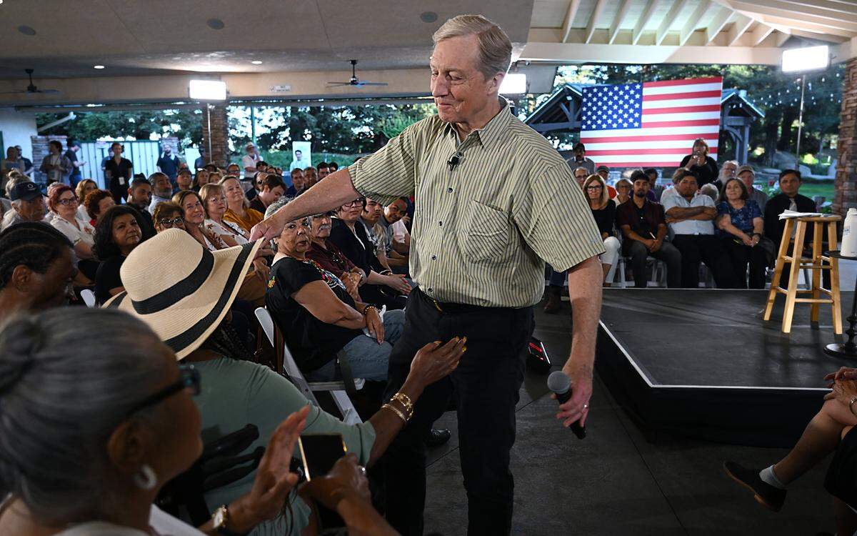 California gubernatorial candidate Tom Steyer hugs an audience member during a question and answer portion of an appearance Tuesday evening, April 7, 2026 in Fresno.