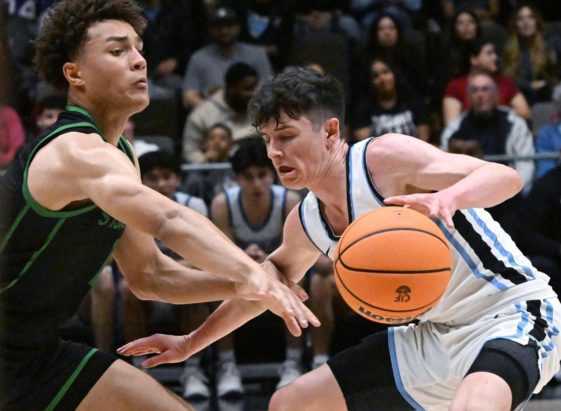 St Joseph’s Julius Price, left, with Clovis North’s Connor Amundsen, right, in the Central Section Division I basketball championship Saturday, Feb. 24, 2024 at Selland Arena in Fresno.