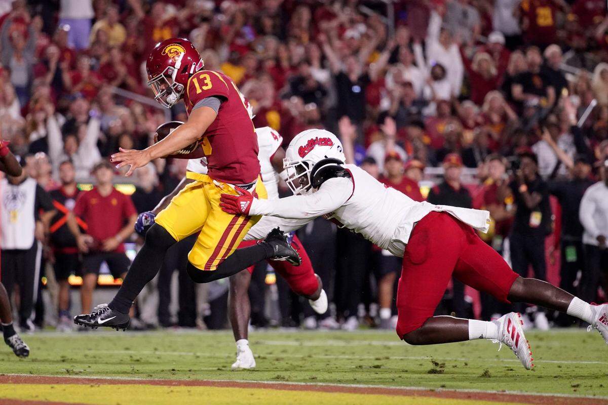 Southern California quarterback Caleb Williams, left, leaps in for a touchdown as Fresno State defensive lineman Devo Bridges attempts a tackle during the first half of an NCAA college football game Saturday, Sept. 17, 2022, in Los Angeles. (AP Photo/Mark J. Terrill)