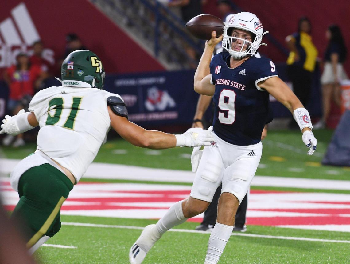 Fresno State quarterback Jake Haener gets off a pass under pressure from Cal Poly’s Dustin Grein, Saturday, Sept. 11, 2021 in Fresno. Haener hit 17 of 22 passes for 380 yards and four TDs in the Bulldogs’ 63-10 victory.