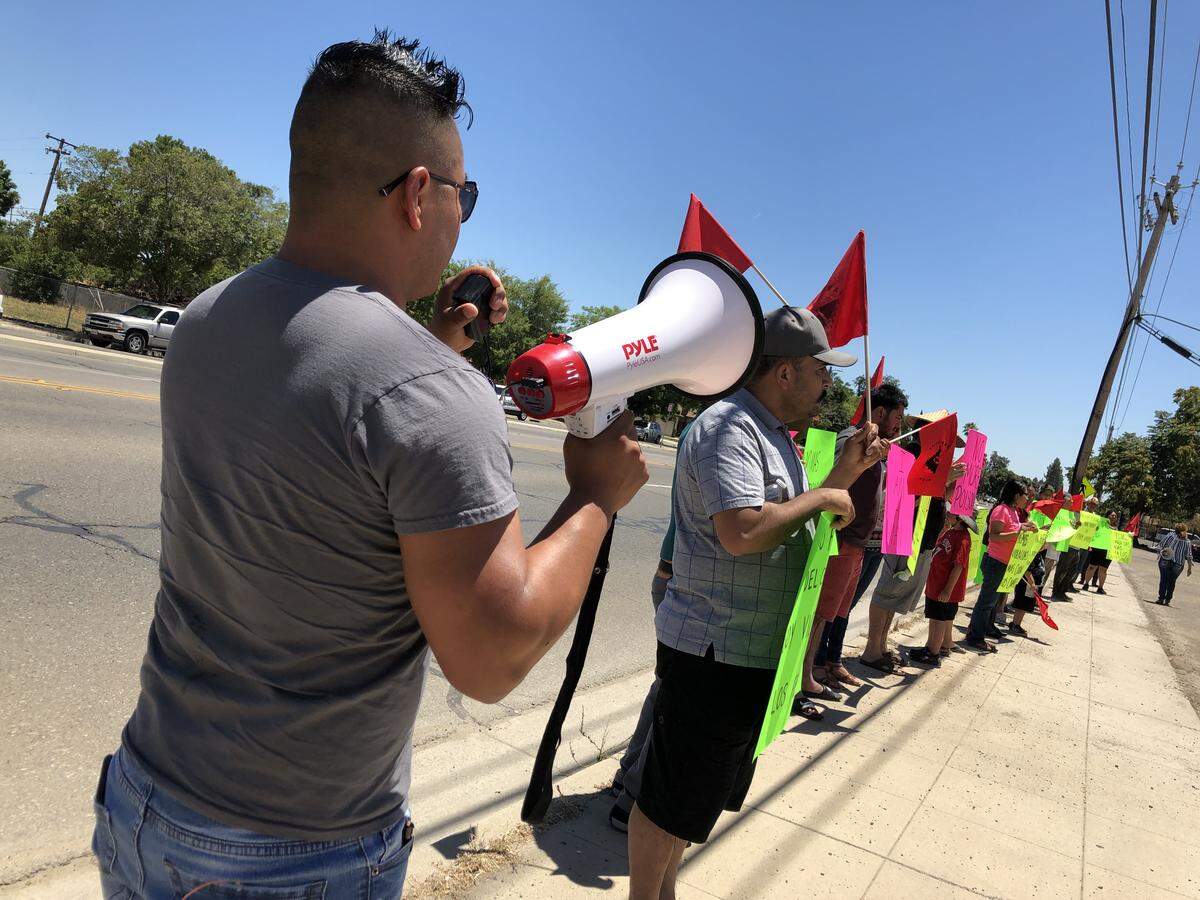 Protesters descended onto the parking lot of the Fresno County Agriculture Commission’s office on June 28, 2019, after dozens of farm workers were exposed to chemicals in two incidents in the region.