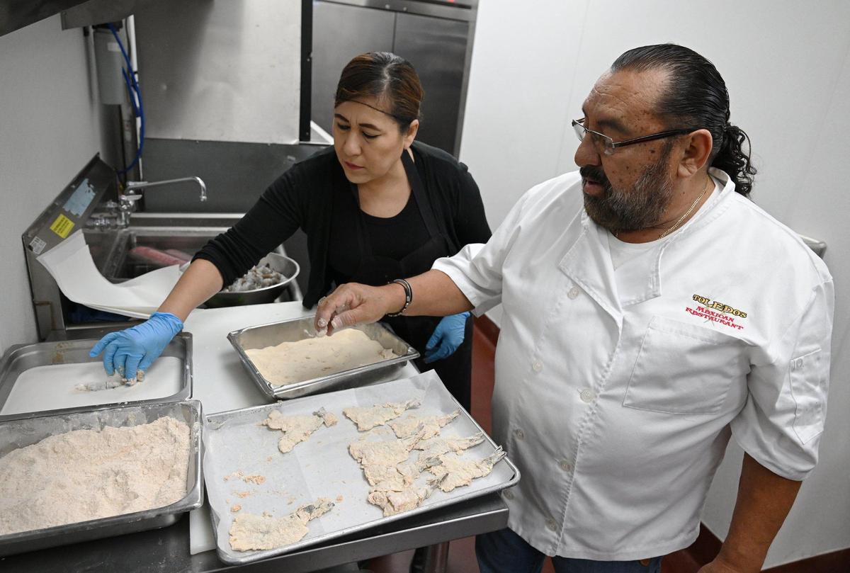 Sam Toledo, right, instructs an employee on how to bread shrimp at the new Toledo’s Mexican Restaurant newly opened at Cedar and Nees avenues Tuesday, April 22, 2025 in Fresno.