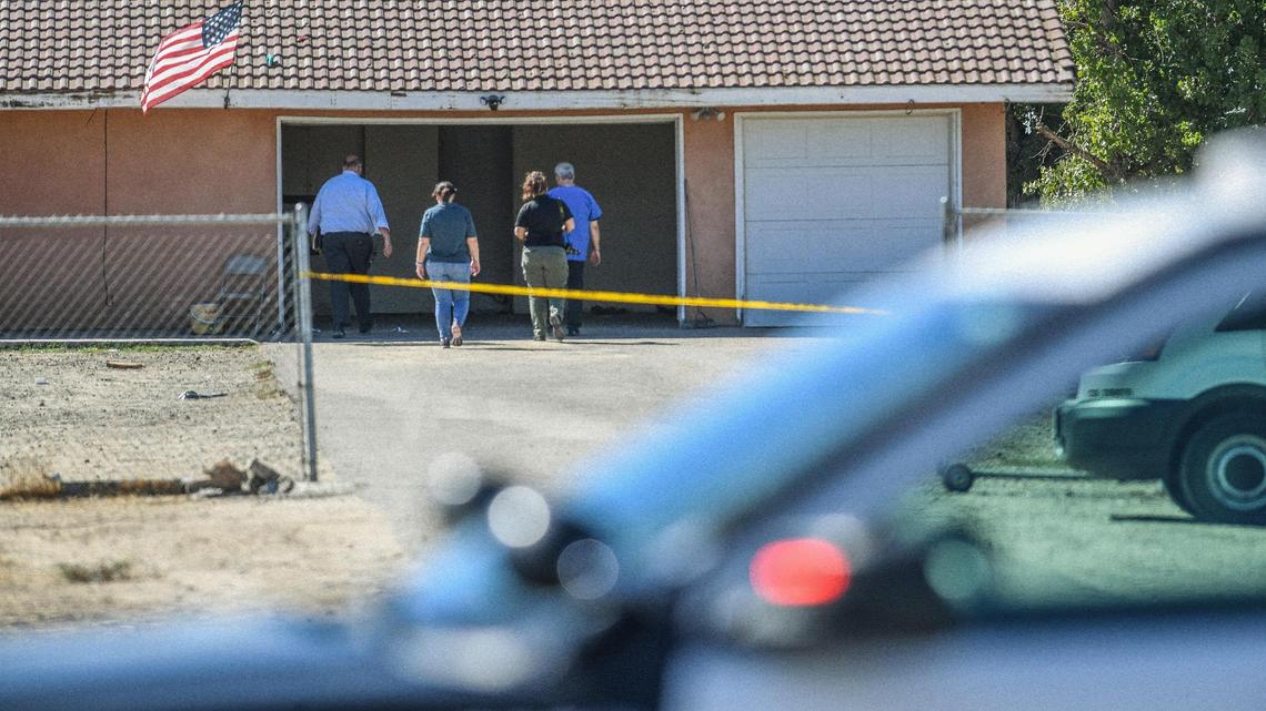 Fresno police investigators walk toward a home in southwest Fresno where police have reported a double-homicide involving a teenage mother and her 3-week-old baby on Saturday, Sept. 24, 2022.