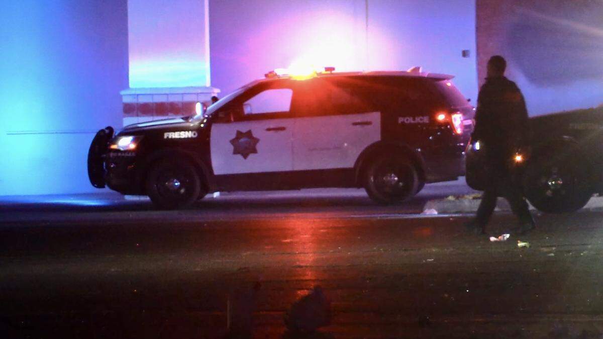 An officer goes through a parking lot following a shooting in Fresno, California on Sunday, March 30, 2025.