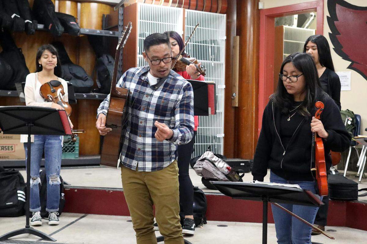 Orosi High School Mariachi Cardenal members listen to Orosi mariachi band director Jonathan Gaspar during their mariachi class on Wednesday, March 15, 2023.