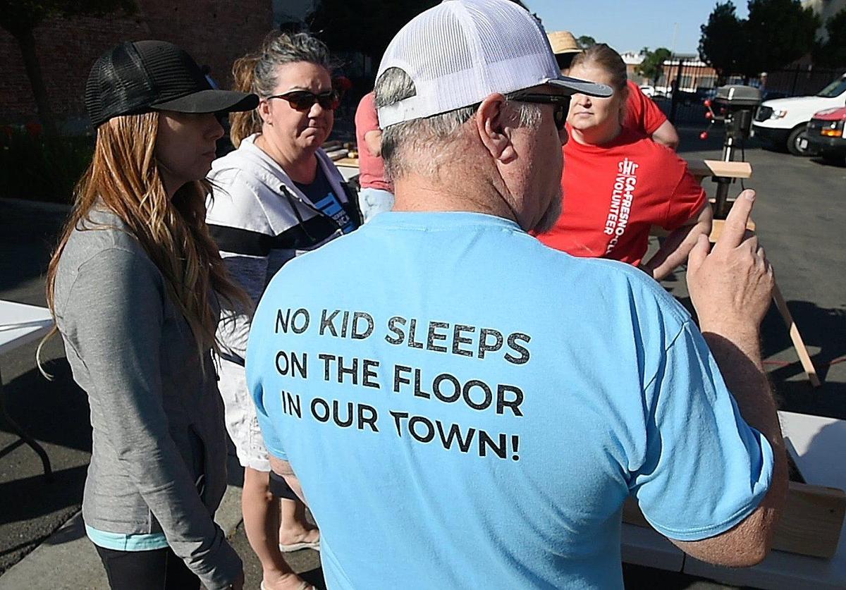 David Burchett’s T-shirt explains the goal of Sleep in Heavenly Peace, as the Fresno chapter works on a Bunk Bed Build for kids in need of beds Saturday morning, May 8, 2021. A bigger build is scheduled June 12 as part of a national Bunks Across America event.