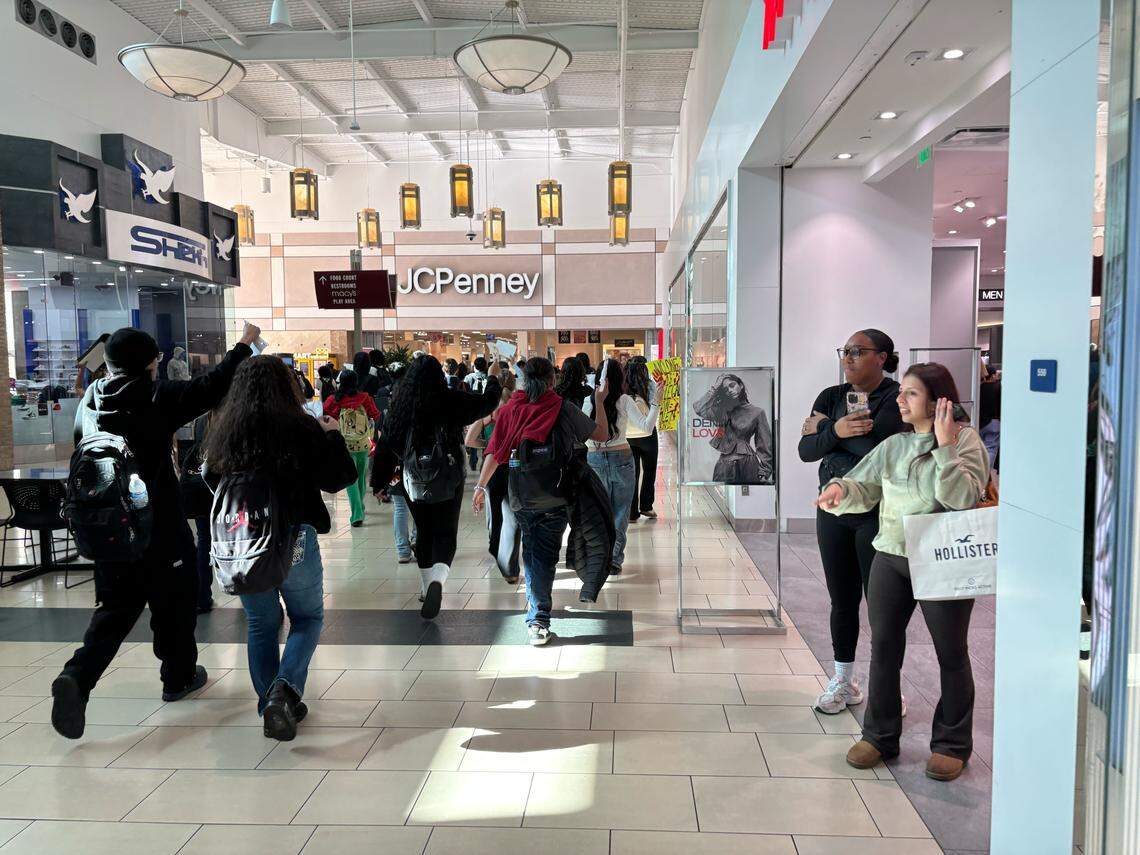 Compradores en Fashion Fair Mall observan mientras estudiantes de Bullard High School marchan por el centro comercial en una protesta contra ICE el miércoles 4 de febrero de 2026.