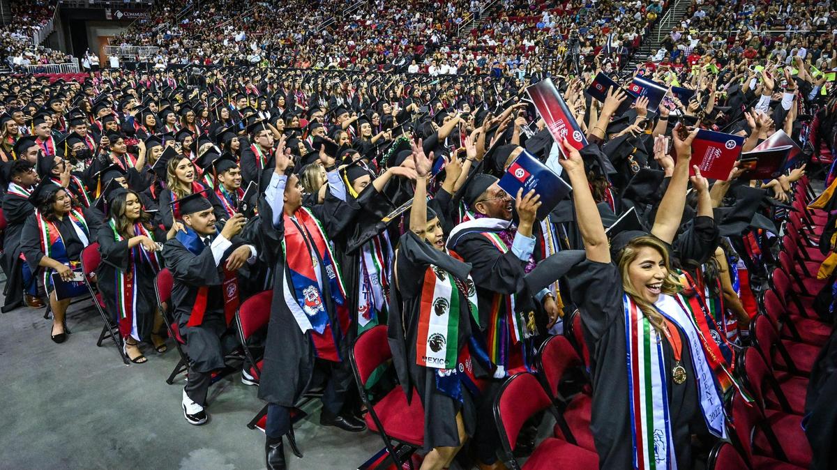 Graduate students do “the wave” during a break in the 46th annual Fresno State Chicano/Latino Commencement held at the Save Mart Center last May.